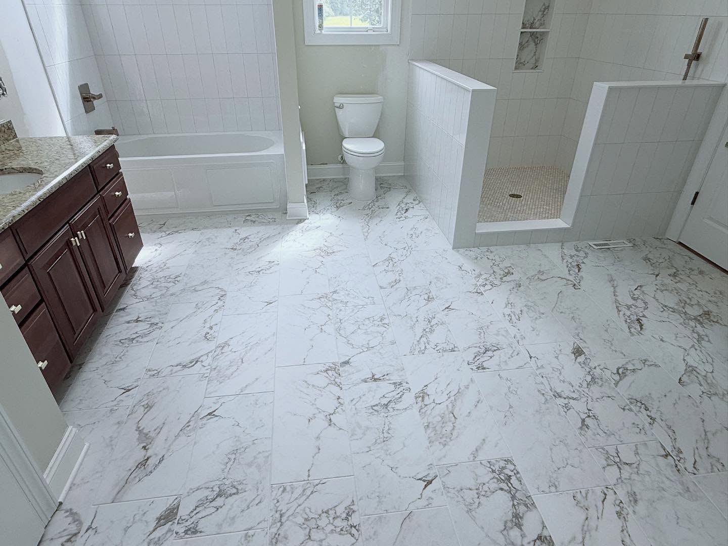 Spacious bathroom with marble floor and tiles.