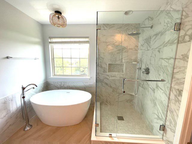 Bright modern bathroom with freestanding tub and glass shower.